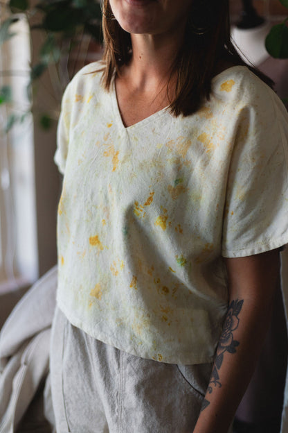 Person wearing a light-colored blouse with floral patterns in a casual setting